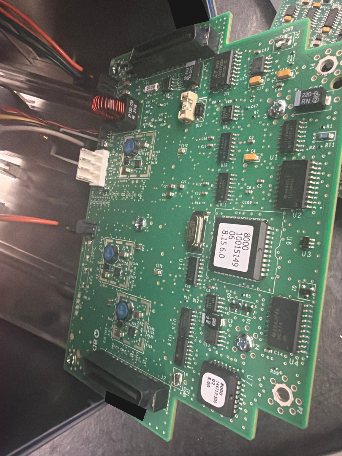 Close view of the Alaris 8015 control board and connectors during service, with equipment identifiers masked.