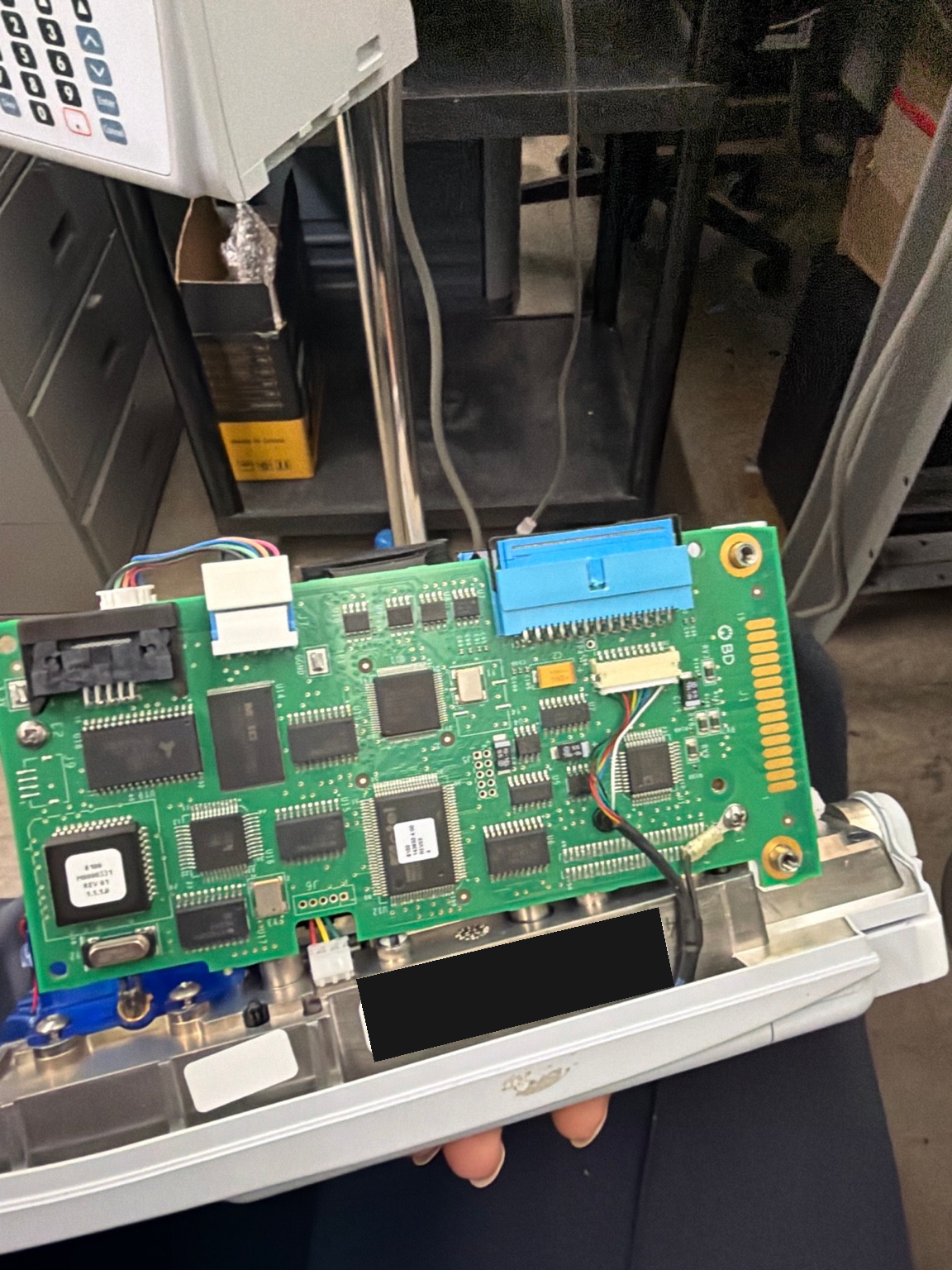 Alaris 8100 control board and internal connections during troubleshooting, with equipment identifiers masked.