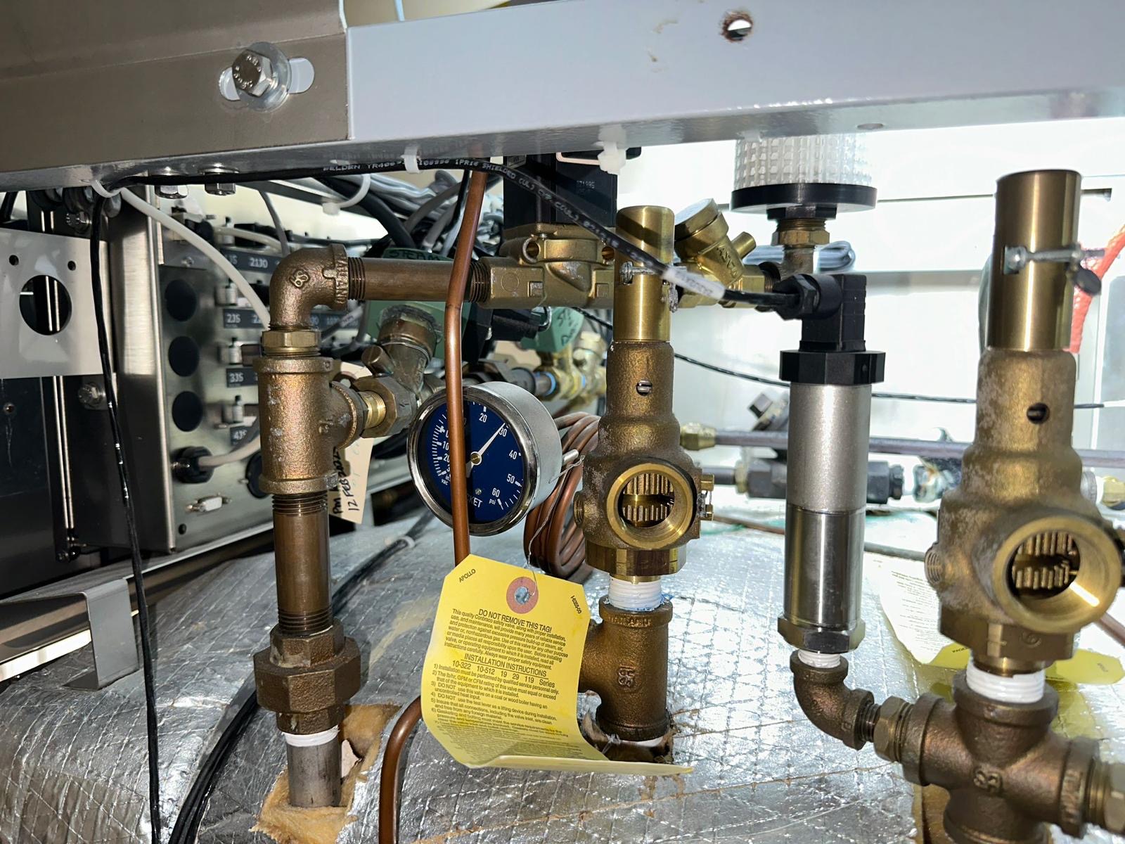 Close view of Getinge sterilizer piping, pressure gauge and brass valve assemblies during service.