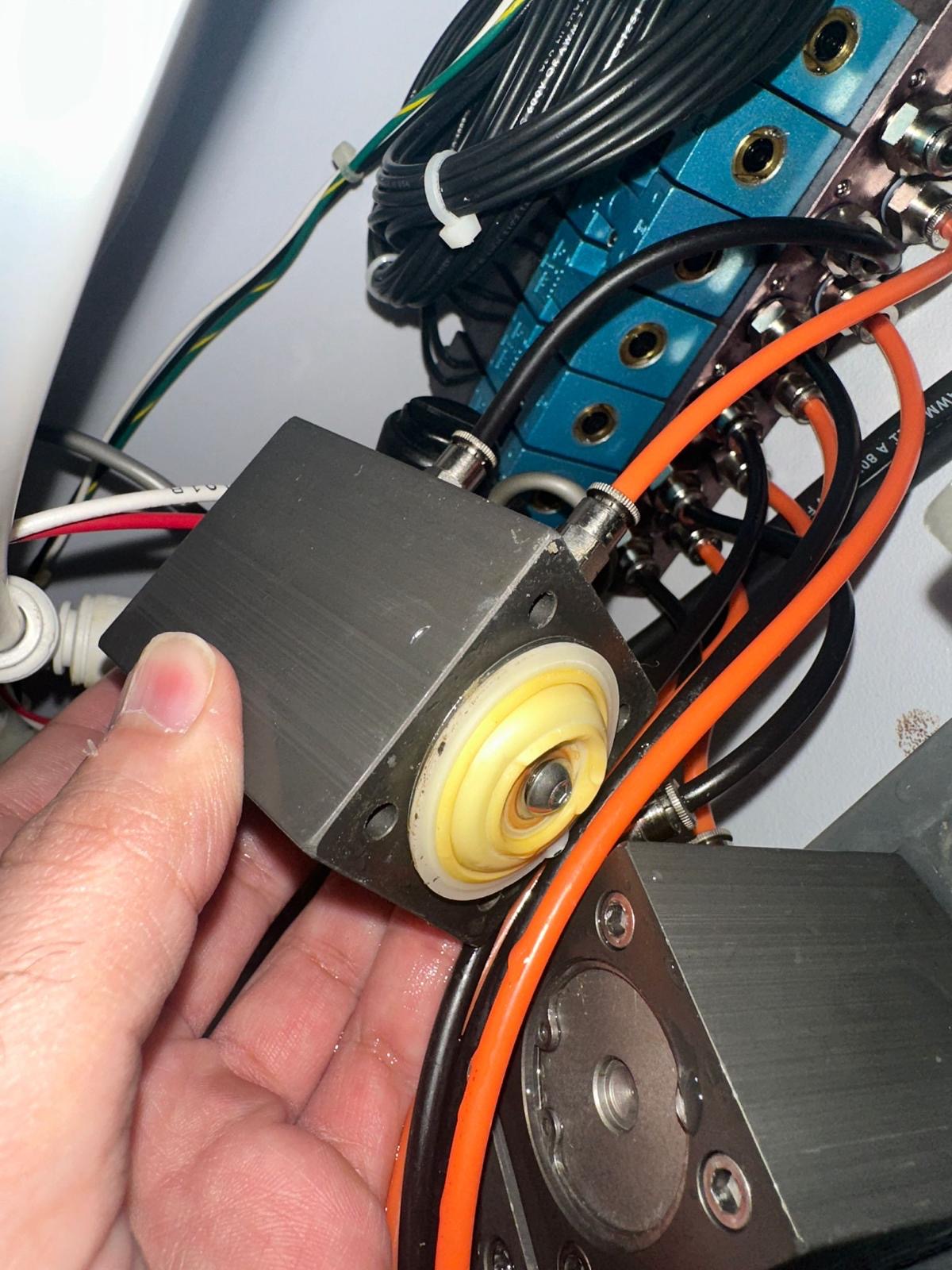 Removed Medivators air valve assembly with visible diaphragm beside the device's pneumatic connections.