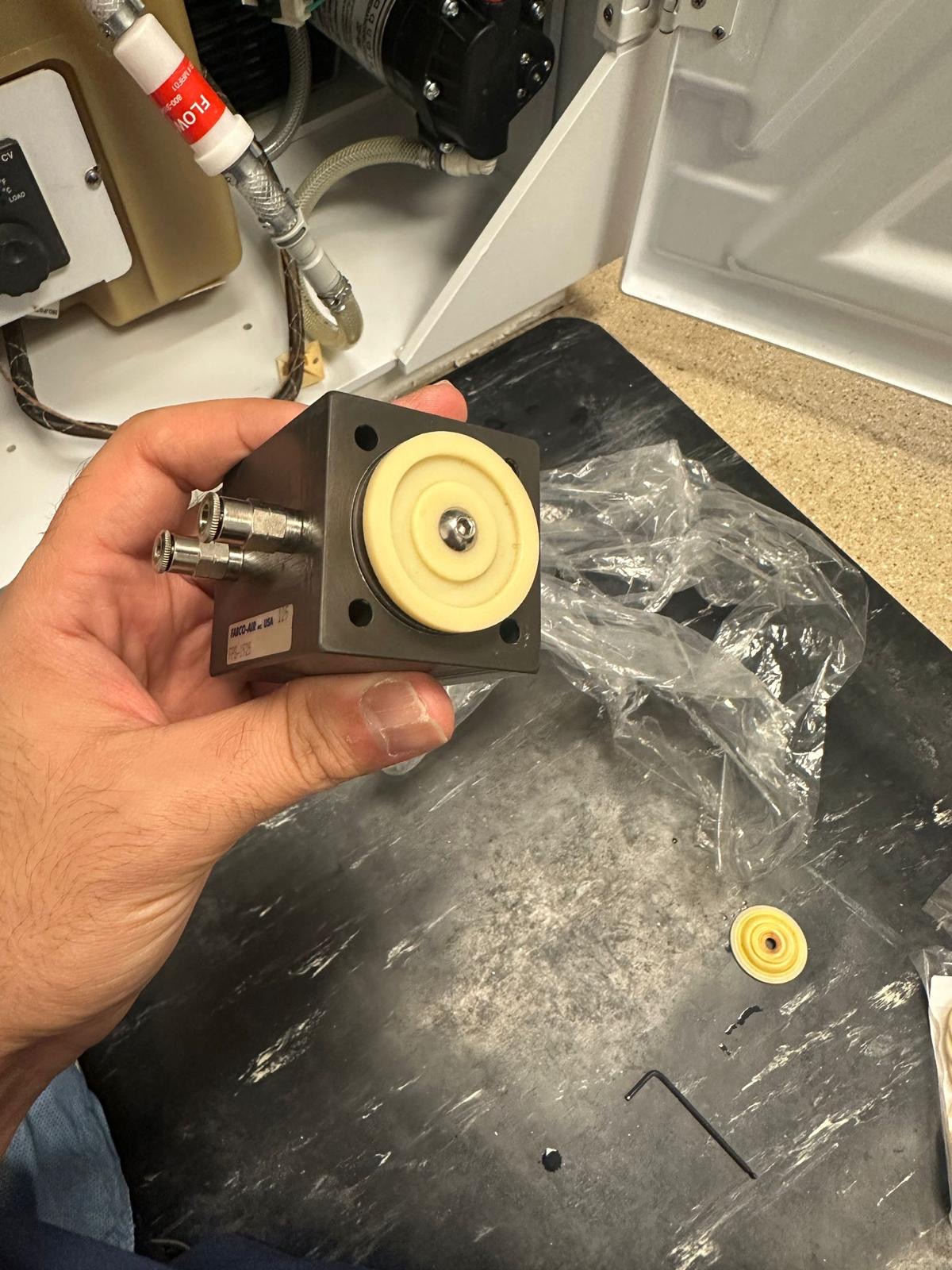 Close view of the Medivators air valve assembly with diaphragm and two pneumatic fittings.