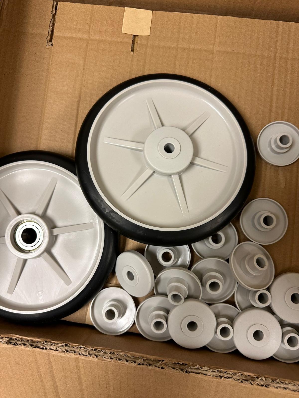 Patient-bed wheels and smaller hub components arranged in a box during wheel service.