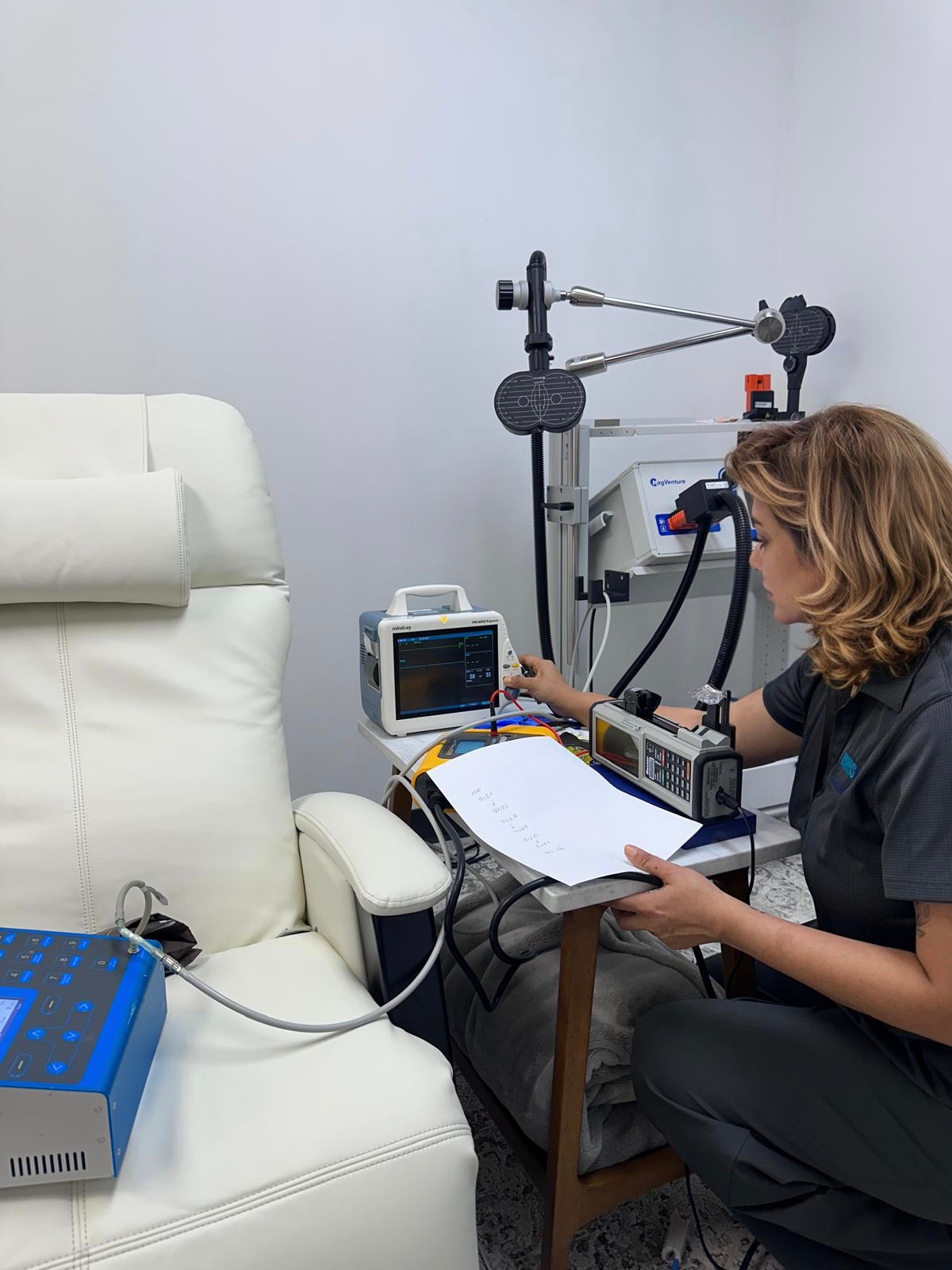 Apex technician checking a Mindray PM-8000 Express patient monitor with test equipment.