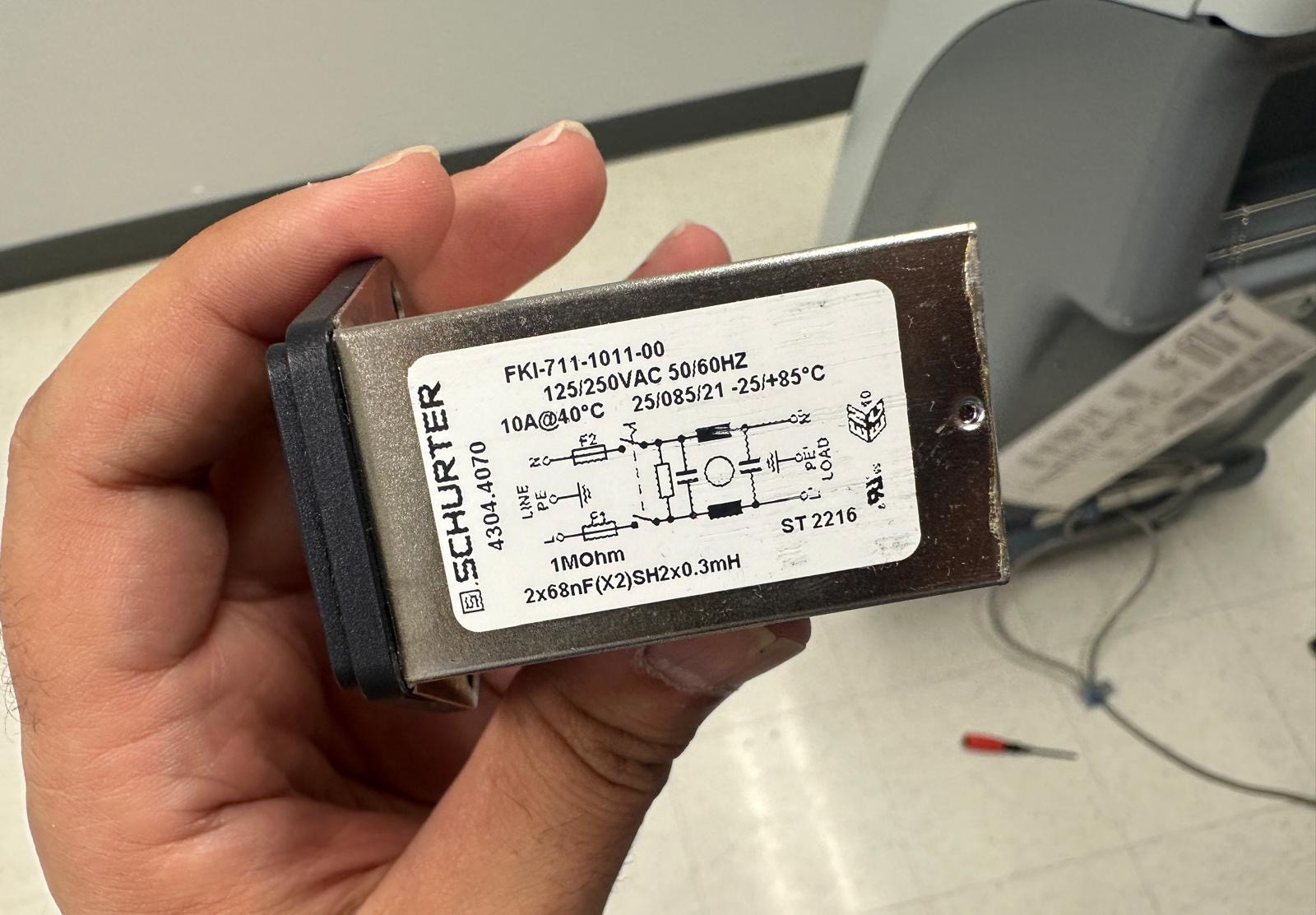 Close-up of the power entry module label during suction-unit service.